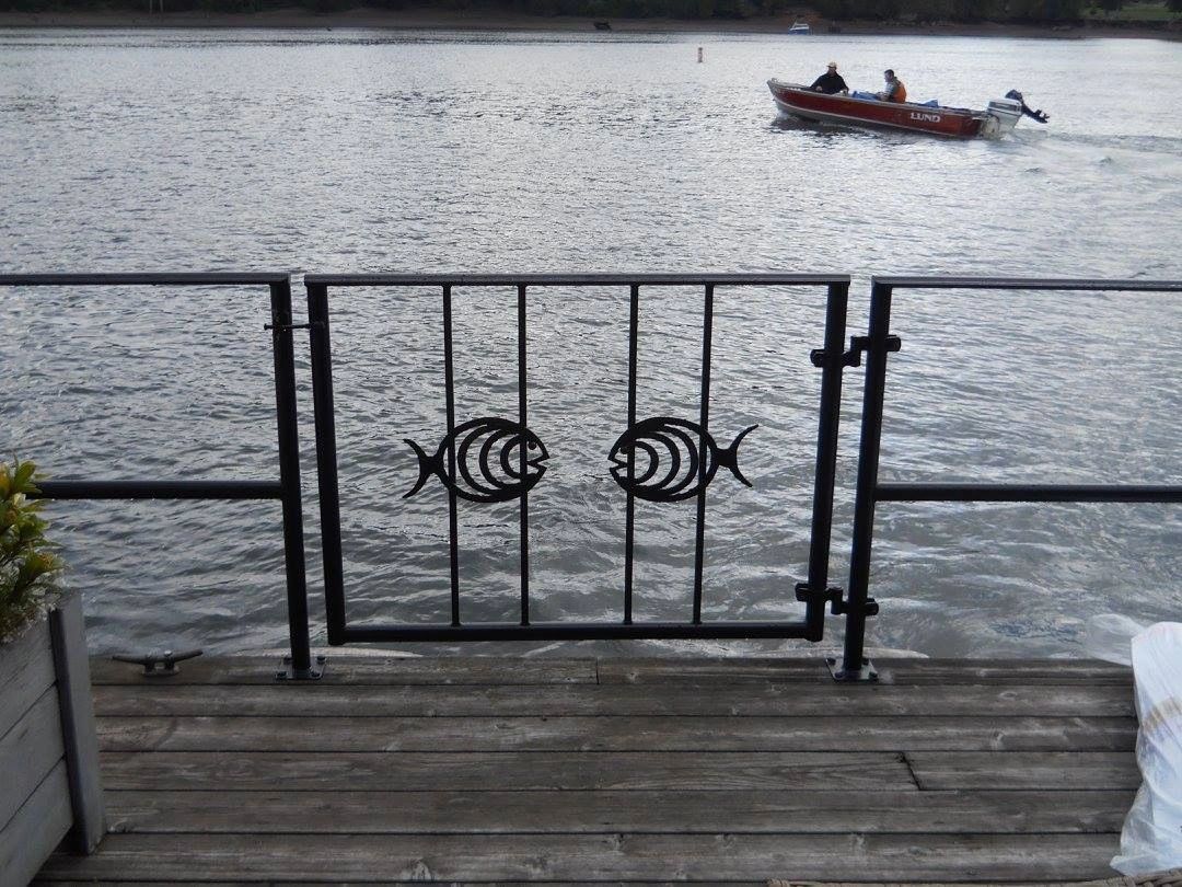 A boat is in the water behind a fence.