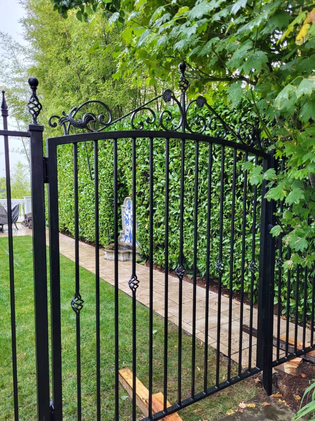 A black metal gate with vines growing on it.