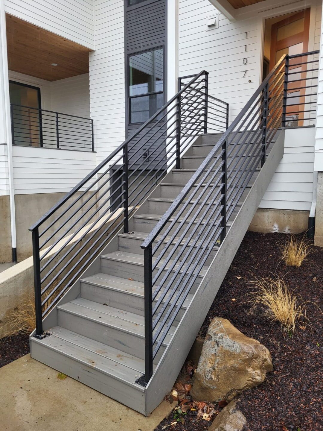 A staircase with metal railing and concrete steps.