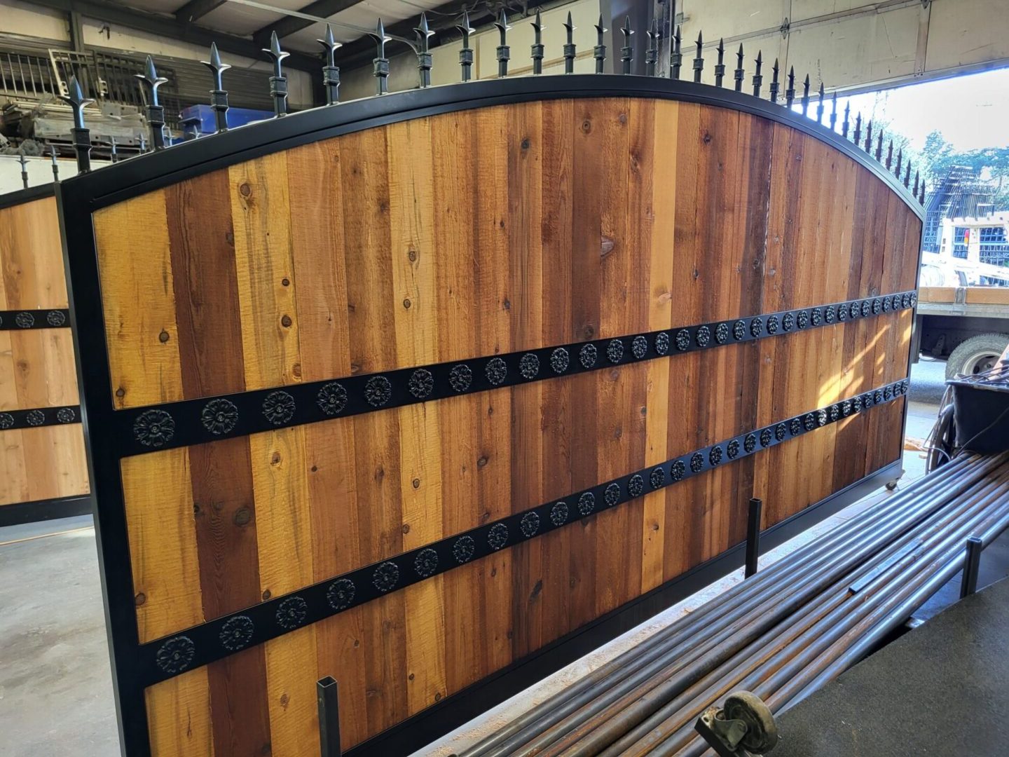 A wooden fence with metal posts and black iron bars.