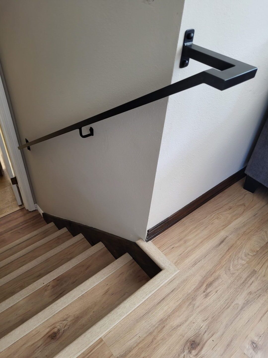 A staircase with wooden steps and black handrails.