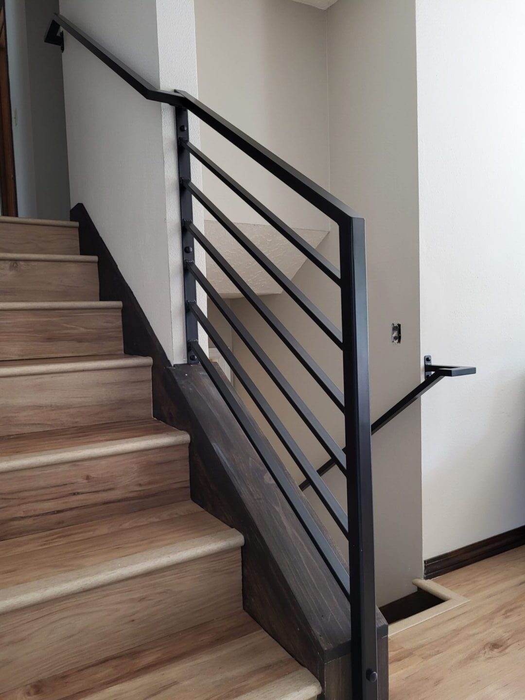 A staircase with metal railing and wood steps.