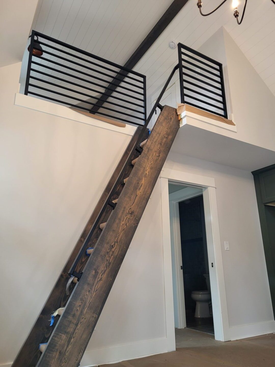 A wooden ladder leading to the top of stairs.