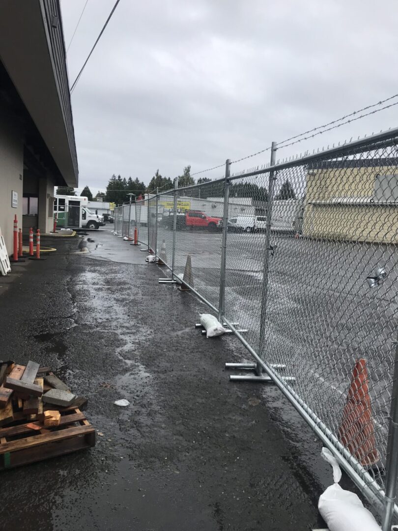 A construction site with metal fence and debris.