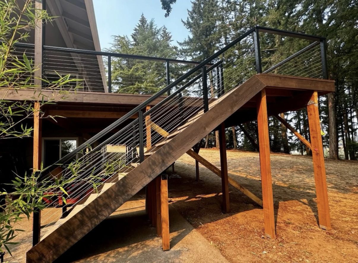 A wooden staircase with metal railing on top of it.