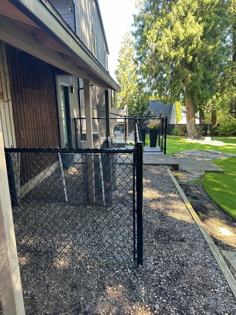A black chain link fence on the side of a house.