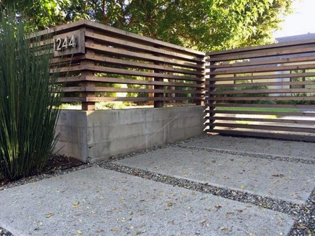 A concrete slab with a wooden fence and a plant.