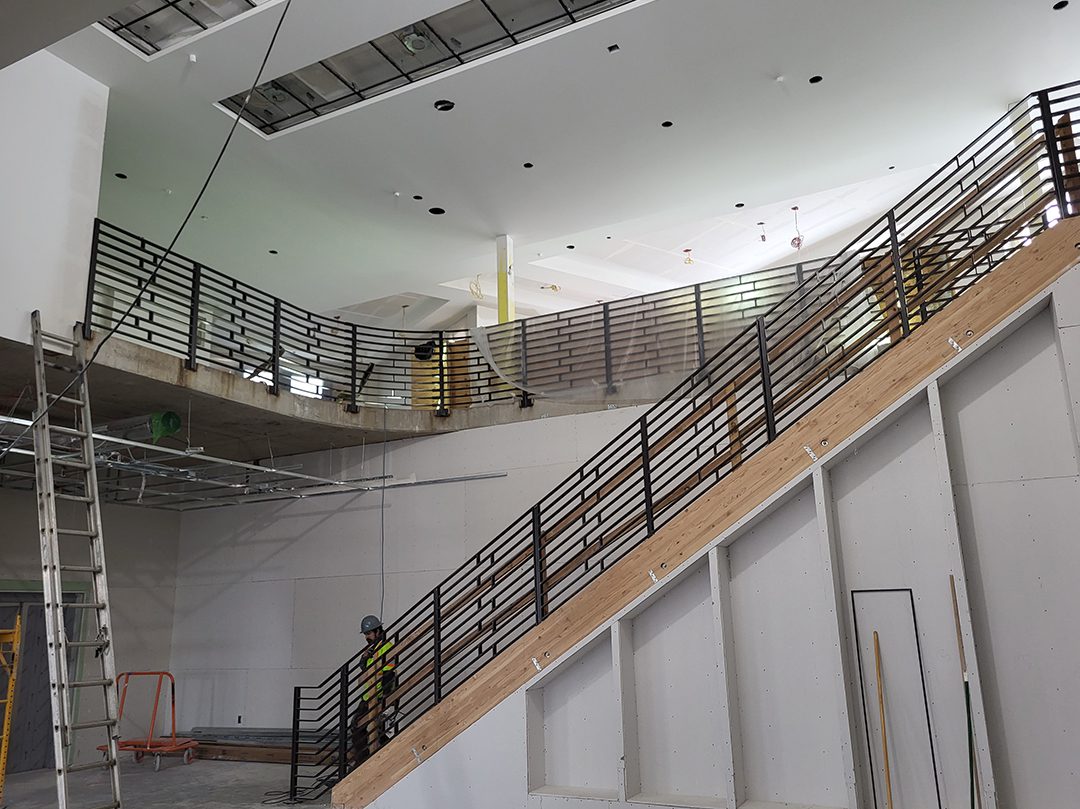 A staircase with metal railing and stairs in the middle.