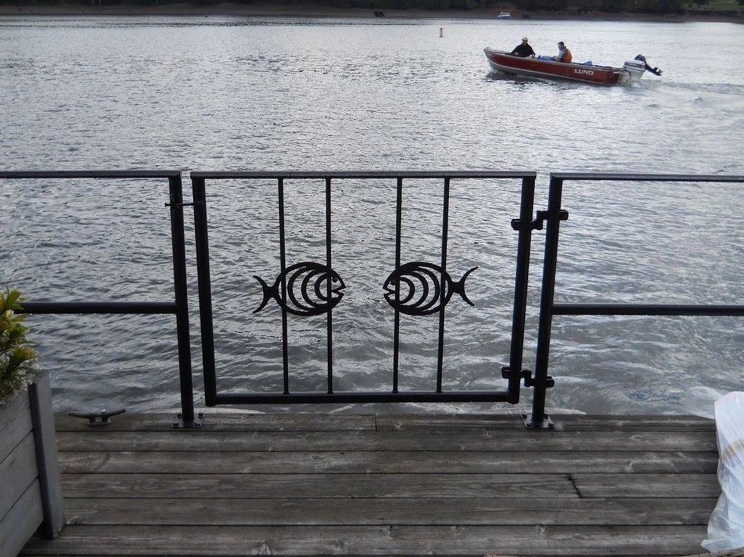 A boat is in the water behind a fence.