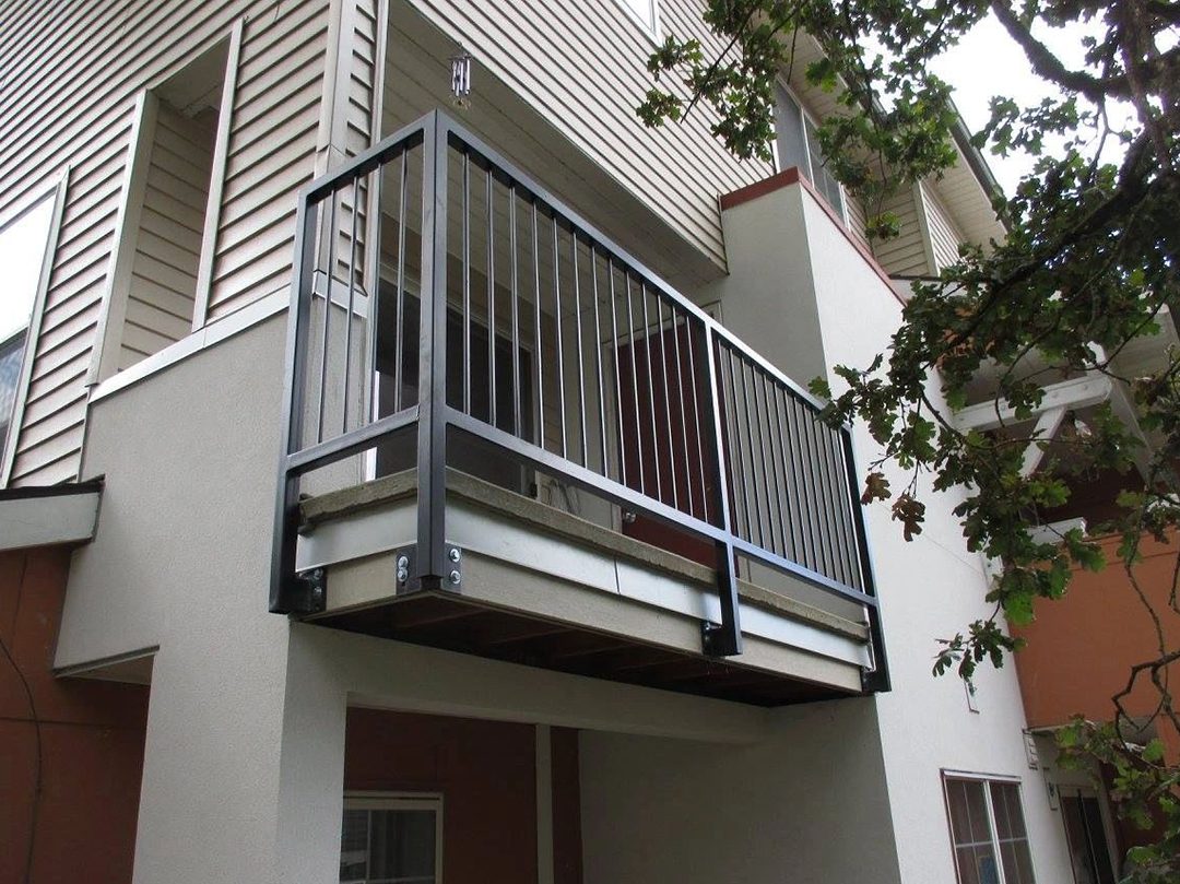 A balcony with metal railing and white walls.