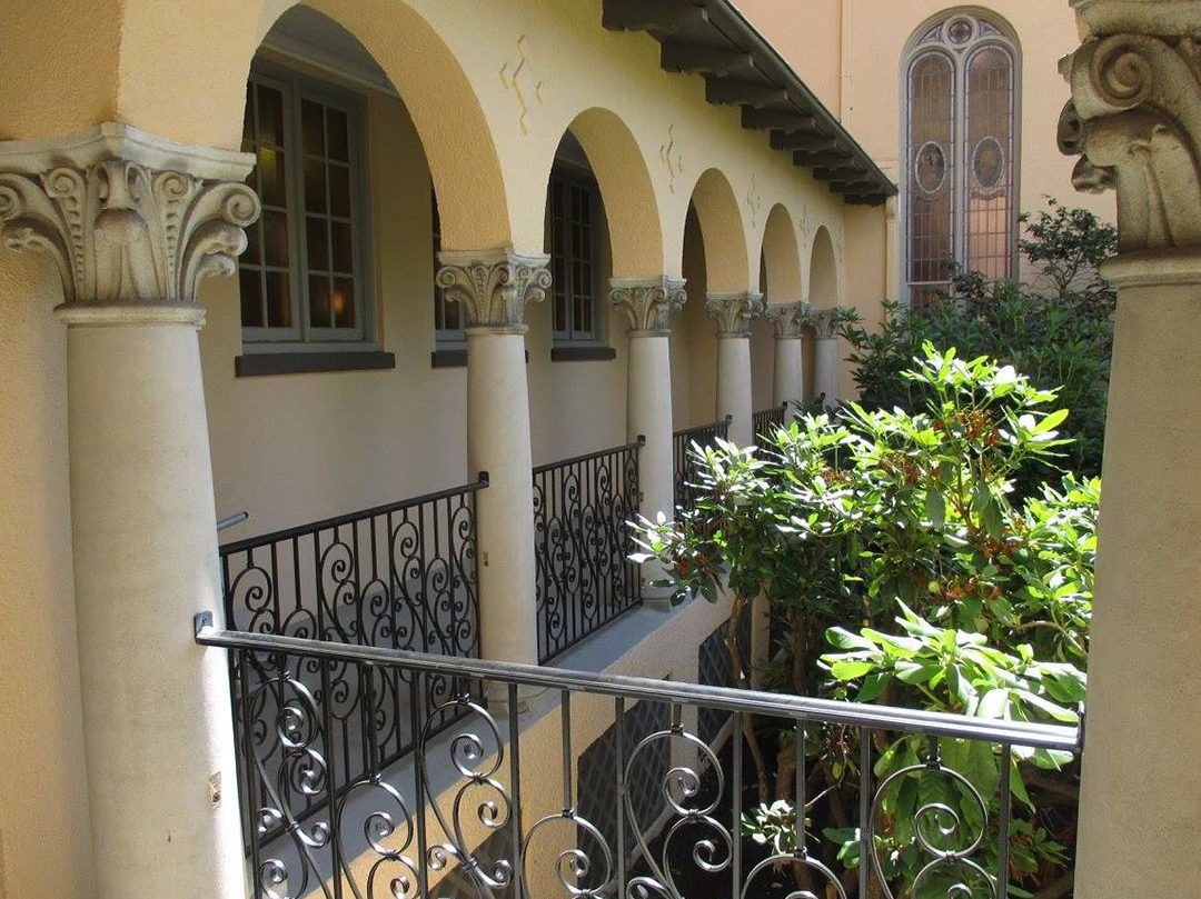 A balcony with wrought iron railings and arches.