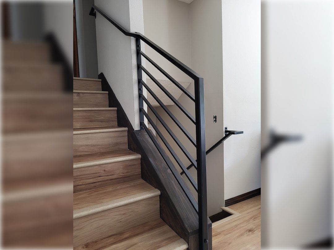 A staircase with metal railing and wood steps.