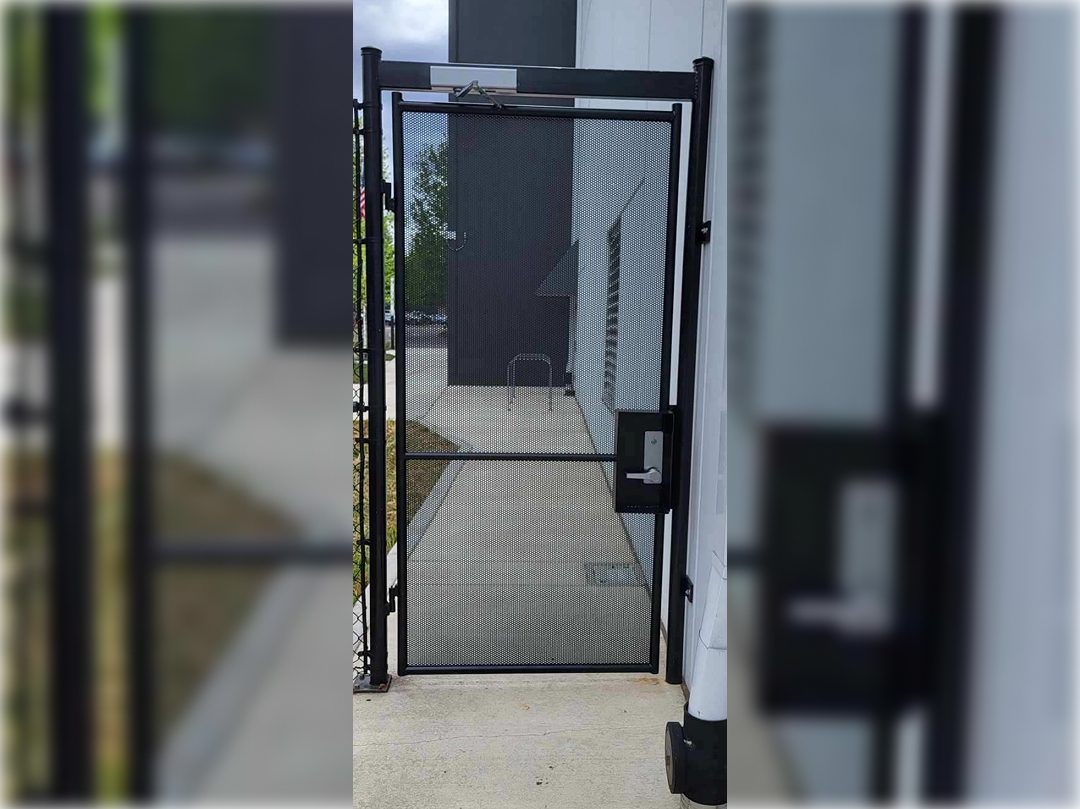 A black metal gate with a glass door.
