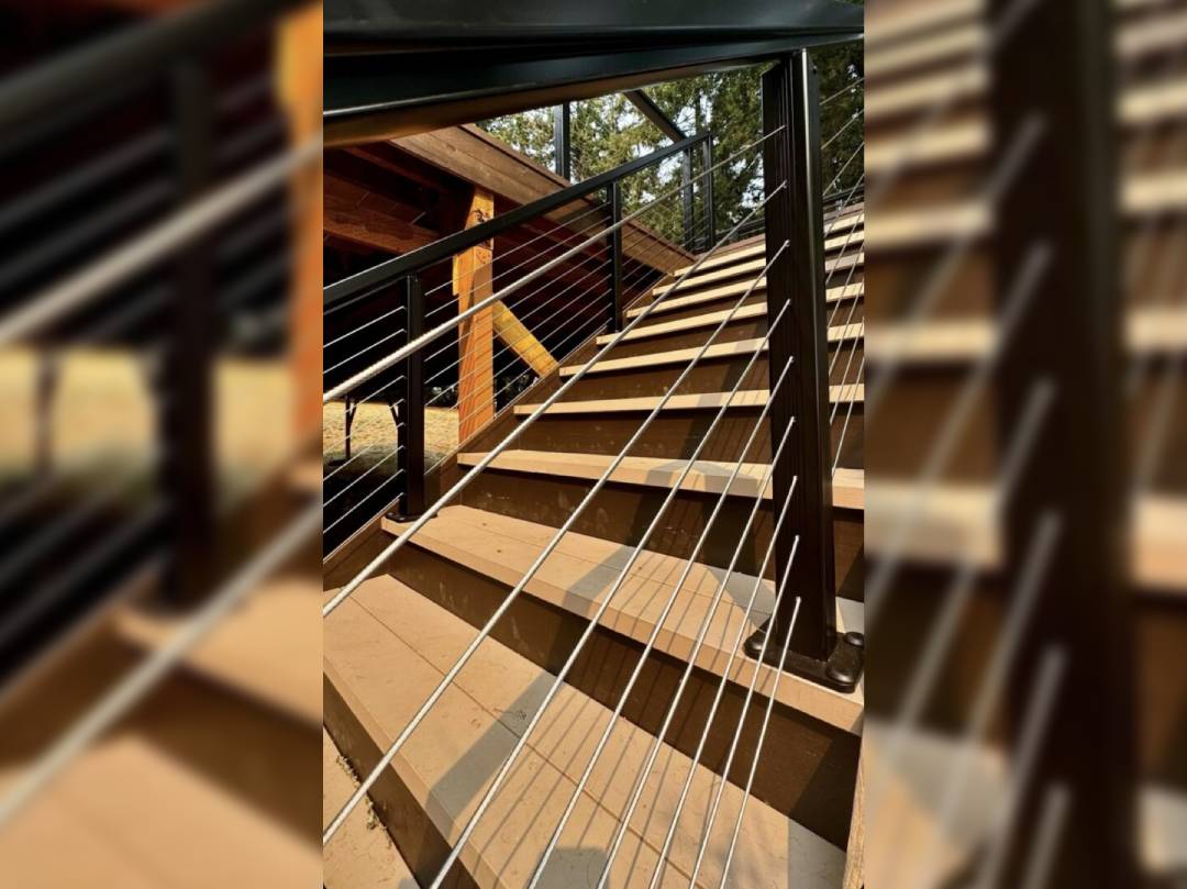 A wooden staircase with metal railing and wood steps.