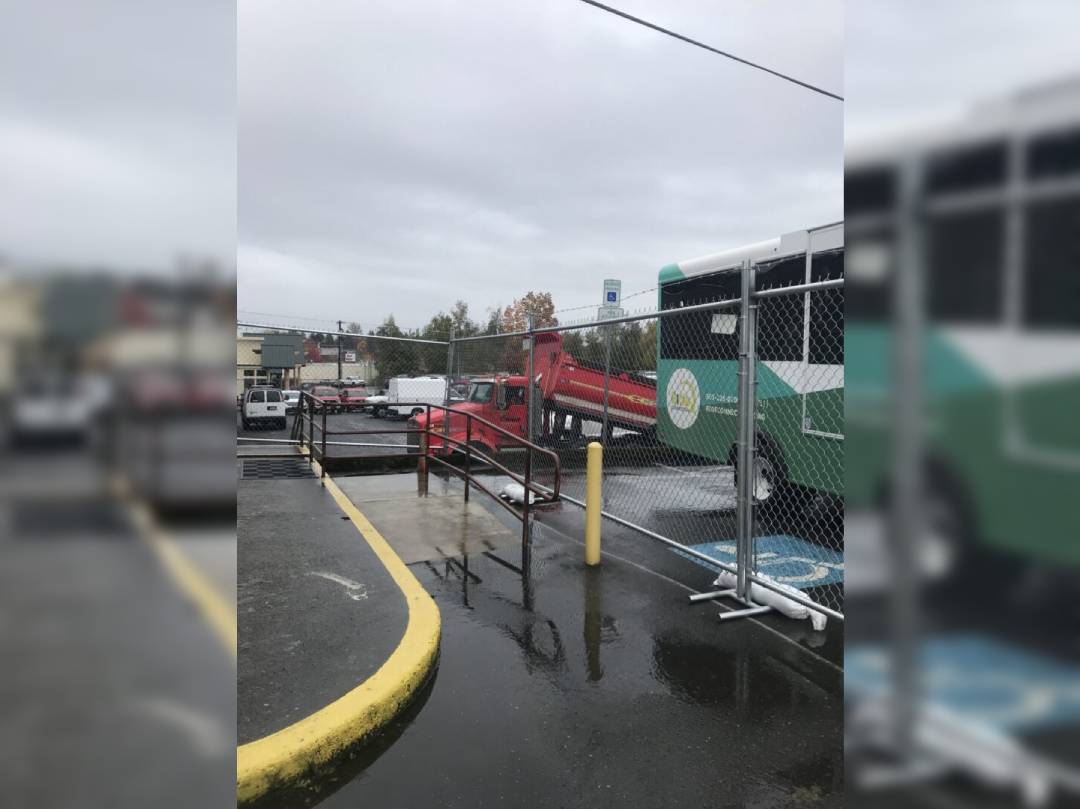 A bus is parked in the middle of a flooded parking lot.