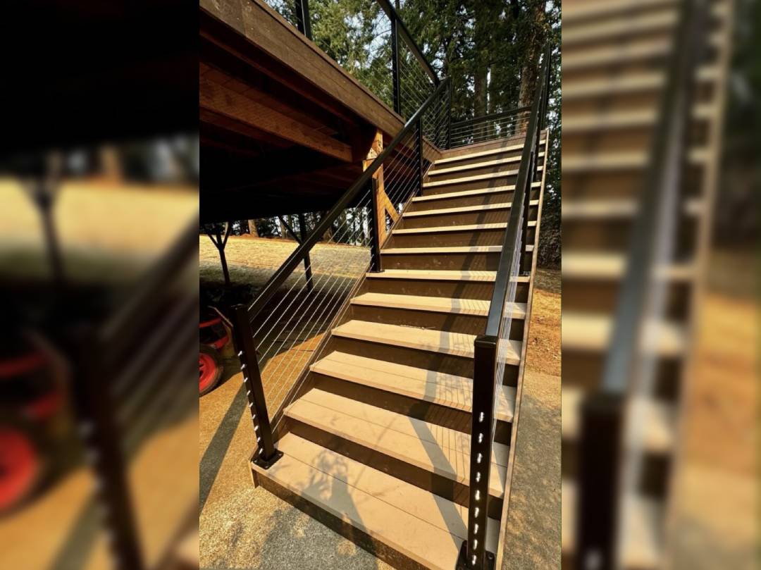 A wooden staircase with metal railing and wood steps.