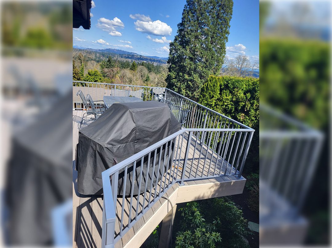 A grill on top of a deck near trees.