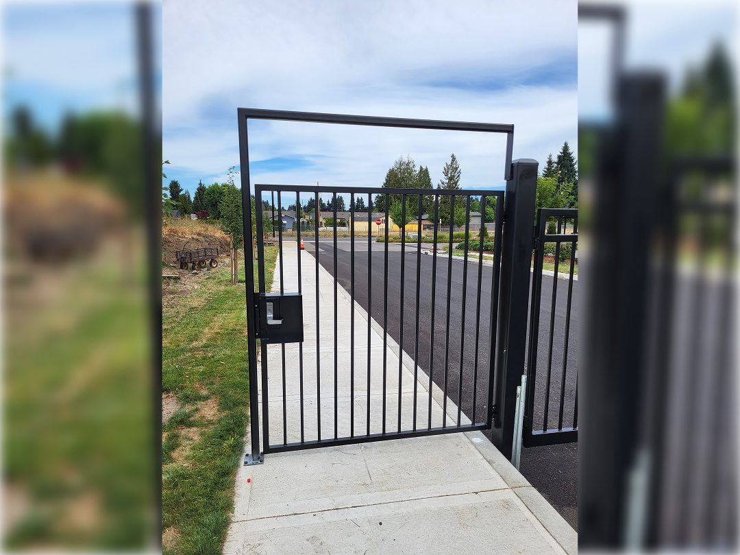 A gate that is open on the side of a road.
