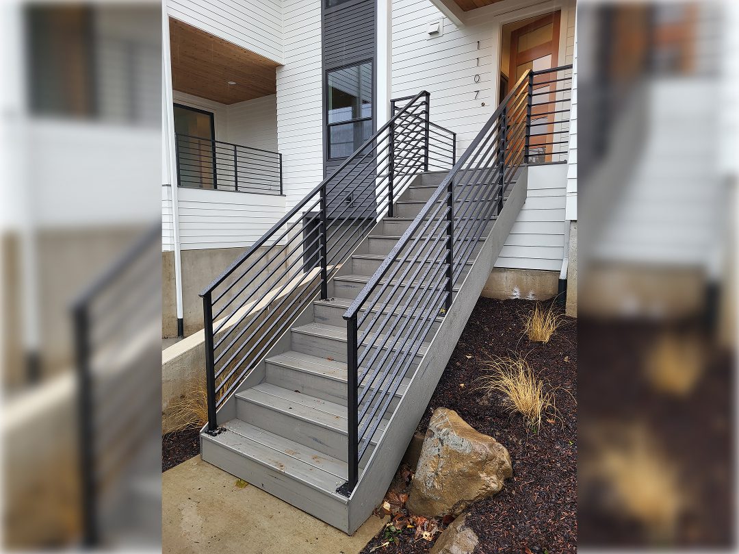 A staircase with metal railing and concrete steps.